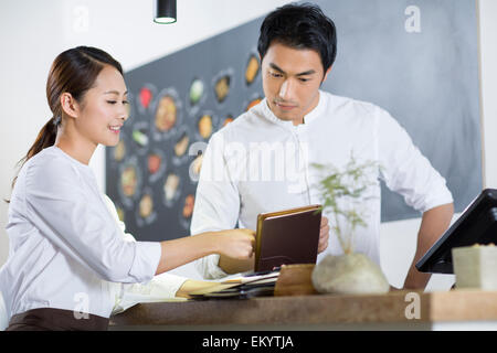 Junge Kellnerin und Kasse Stockfoto