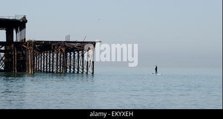 Brighton, Sussex UK 15. April 2015 - ein Mann fischt aus seiner Paddel Board von der West Pier Brighton bei schönstem Wetter früh mit Temperaturen voraussichtlich 24 Grad im Laufe des Tages Credit: Simon Dack/Alamy Live News Stockfoto