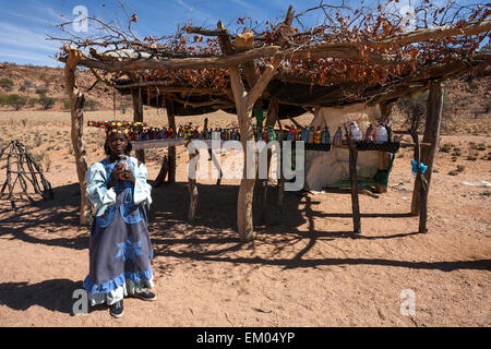 Namibischen Herero Mädchen in typischer Kleidung vor einem Stall mit den Herero-Puppen in Uis, Namibia Stockfoto