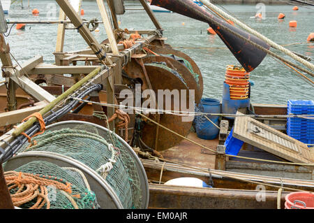 Angeln net und gewundenen Mechanismus auf Trawler Schiff vertäut im Hafen von Looe, Cornwall, England Stockfoto