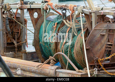 Angeln net und gewundenen Mechanismus auf Trawler Schiff vertäut im Hafen von Looe, Cornwall, England Stockfoto