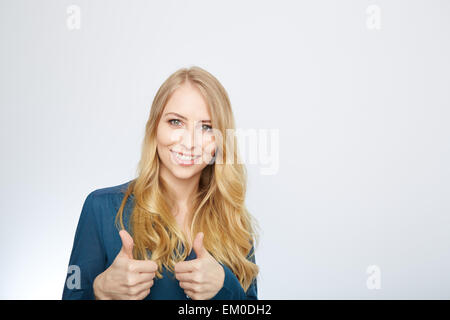 Junge Frau mit Daumen Stockfoto