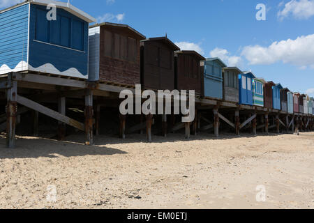 Eine Reihe von bunten Strandhäuschen an einem teilweise bewölkten Tag in Frinton-on-Sea, Essex UK Stockfoto