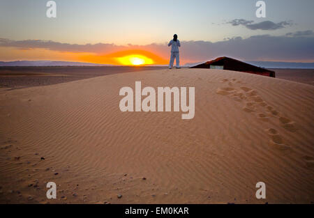 Sahara Wüste Türen Bereich Szene. Ein Mann nimmt Bilder oben auf der Düne, Zagora, Marokko Stockfoto