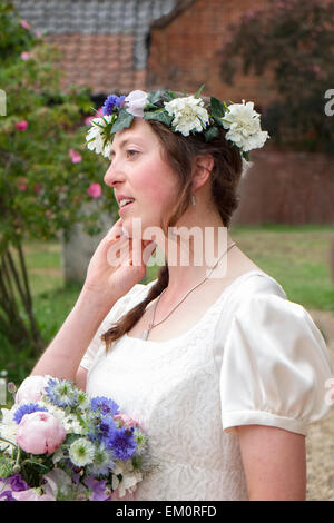 Braut mit natürlichen Blumen Kranz und Strauß warten auf Kirche betreten Stockfoto