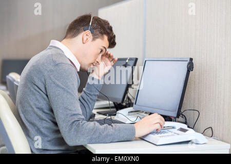 Gespannten Customer Service Representative bei der Rezeption Stockfoto