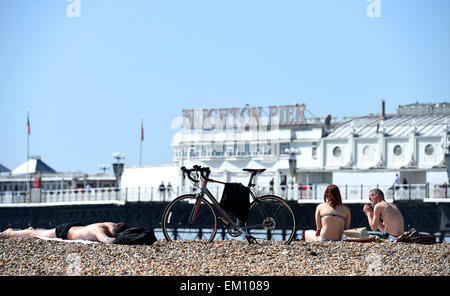 Brighton Sussex UK - die Menschen genießen heute die heiße April-Sonne am Brighton Beach am Pier mit Temperaturen, die für heute Nachmittag auf bis zu 24 Grad Celsius ansteigen werden. Gutschrift: Simon Dack/Alamy Live News Stockfoto
