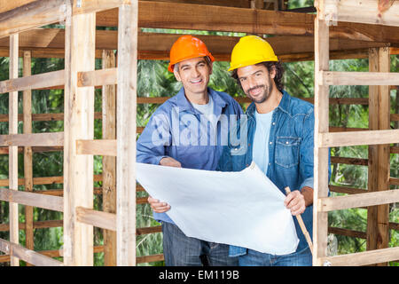 Zuversichtlich Bauarbeiter mit Blueprint am Standort Stockfoto