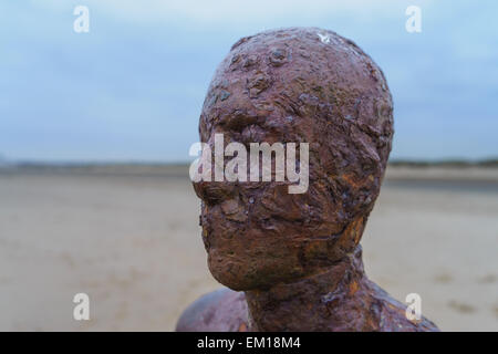 Die rostigen Gesicht eines der Statuen von Antony Gormley "Woanders" Kunstinstallation am Crosby Strand, Liverpool, England. Stockfoto