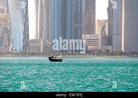 Eine Dhau-Boot pflügt die Gewässern des Arabischen Golfs in der Nähe von der Skyline von Doha, der Hauptstadt von Gulf Nation von Katar.