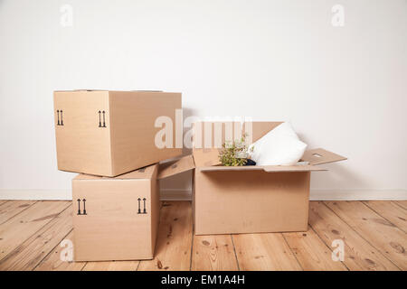 drei Umzugskartons auf Holzboden Stockfoto