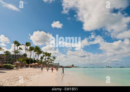 Touristen genießen Türkis farbigen Wasser von Palm Beach unter blauem Himmel in Aruba. Stockfoto