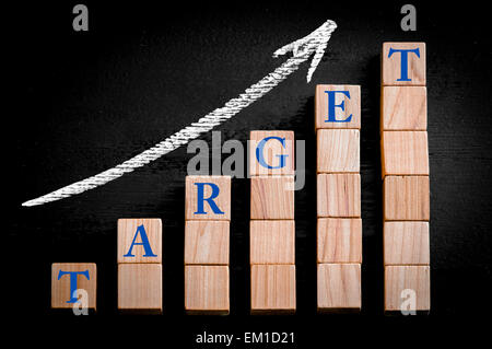 Wort-Ziel auf aufsteigender Pfeil oben Balkendiagramm der hölzerne kleine Würfel auf schwarzem Hintergrund isoliert. Kreidezeichnung auf Tafel. Stockfoto