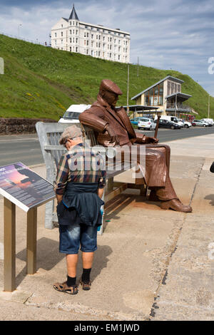 Großbritannien, England, Yorkshire, Scarborough, North Sands, Fred Gilroy Statue von Ray Lonsdale, Besucher betrachten Informationstafel Stockfoto