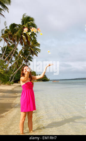 Junge Frau am Strand werfen Blumen in der Luft, Ofu Insel Tonga Stockfoto