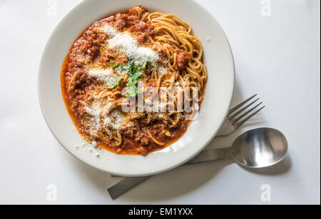 Spaghetti Bolognese in einer weißen Schüssel auf einem weißen Tisch Stockfoto