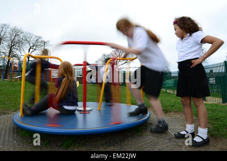 Kinder auf einem Spielplatz spielen. Bild: Scott Bairstow/Alamy Stockfoto