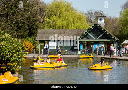 Leute sitzen durch das Bootfahren See Regents Park London UK Stockfoto