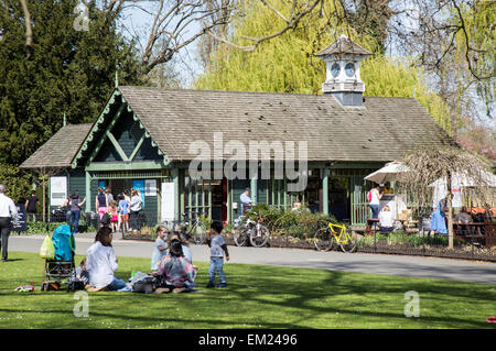 Leute sitzen durch das Bootfahren See Regents Park London UK Stockfoto