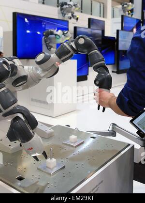 Hannover, Deutschland. 15. April 2015. Ein Besucher erlebt den YuMi Roboterarm auf der Hannover Industrie Messe, Hannover, am 15. April 2015. Die jährlichen Hannover Industrie-Messe, Hannover Messe offiziell eröffnet am Sonntagabend, mit Schwerpunkt für das dritte Jahr in Folge die Integration von konventionellen Industrie und IT Branche. © Luo Huanhuan/Xinhua/Alamy Live-Nachrichten Stockfoto