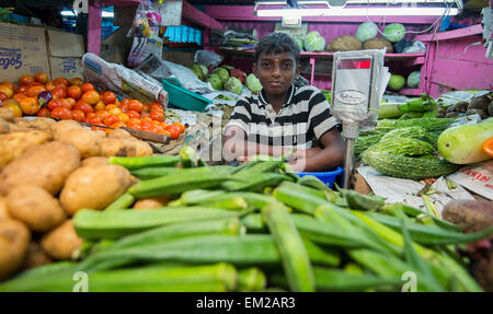 Ein kleiner Junge auf einem Gemüse Stand auf dem Markt von Munnar, Kerala Indien Stockfoto