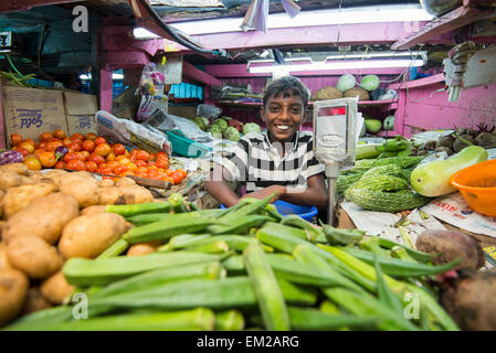 Ein kleiner Junge auf einem Gemüse Stand auf dem Markt von Munnar, Kerala Indien Stockfoto