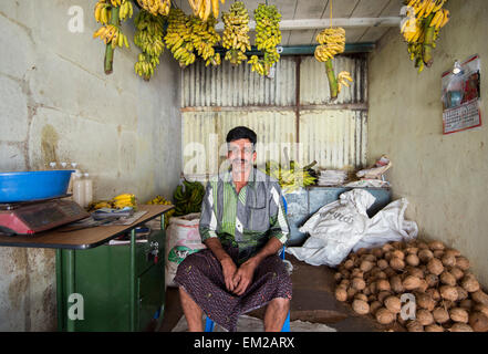 Ein Mann, der Verkauf von Bananen und Kokosnüsse in Munnar, Kerala Indien Stockfoto