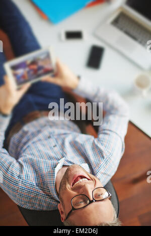 Freudige Geschäftsmann mit Touchpad Pause Stockfoto