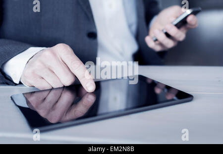 Geschäftsmann mit Smartphone und Tablet closeup Stockfoto