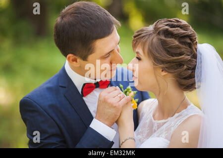 Glückliche Braut, Bräutigam, stehend im grünen Park, küssen, Lächeln, lachen. Close-up Stockfoto