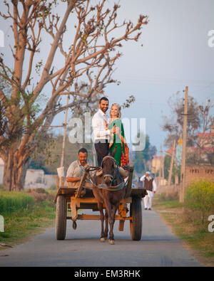 Eine Mischrasse paar In einer Umarmung auf einem Wagen, gezogen von einem Pferd stehend; Ludhiana, Punjab, Indien Stockfoto
