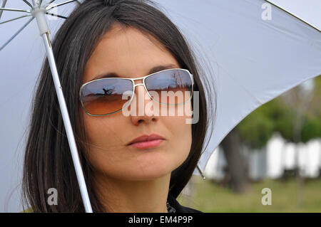 Frauen mit einem weißen Schirm in einem park Stockfoto