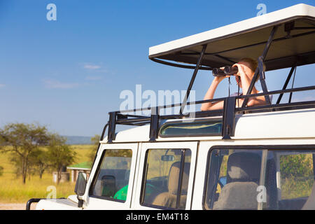 Frau auf Safari durch ein Fernglas schauen. Stockfoto