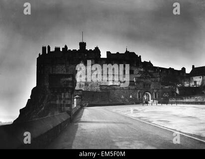 Das Licht von der Princes Street bildet einen Heiligenschein um Edinburgh Castle, wie Dämmerung auf die schottische Hauptstadt, ca. 1935 fällt. Stockfoto