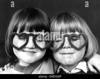 Vier Jahre alten Sheldon Neal (rechts) und Terry Green, tragen Liebe herzförmige Brille im Regenbogen Kindergarten in Brighton. 12. Februar 1976. Stockfoto