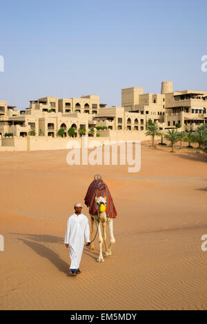 Arabische Mann mit Kamel im Qasr al Sarab Hotel Anantara in leeren Viertels von Abu Dhabi Vereinigte Arabische Emirate Stockfoto