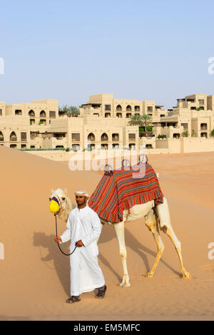 Arabische Mann mit Kamel im Qasr al Sarab Hotel Anantara in leeren Viertels von Abu Dhabi Vereinigte Arabische Emirate Stockfoto