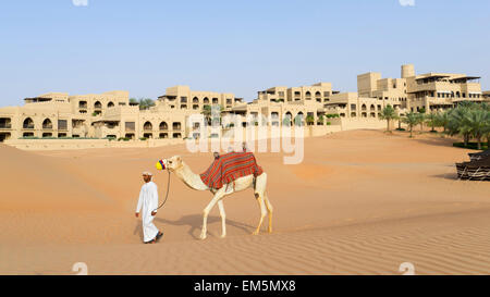 Arabische Mann mit Kamel im Qasr al Sarab Hotel Anantara in leeren Viertels von Abu Dhabi Vereinigte Arabische Emirate Stockfoto