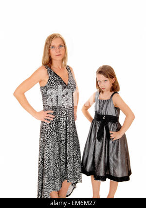 Eine Mutter mit ihrer kleinen Tochter in Kleider für weißen Hintergrund haben Sie Probleme mit einander stehen. Stockfoto