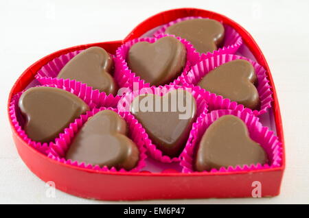 Herrlich sucht Herz geformt in einer roten herzförmigen Schachtel Schokolade Stockfoto