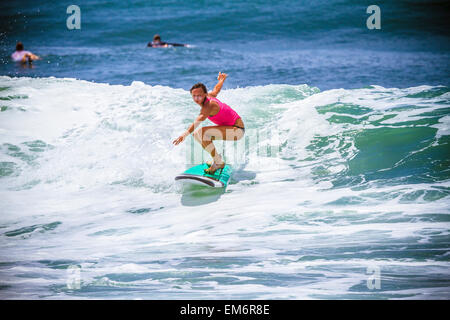 Surfer Mädchen fängt Welle in Highheels. Stockfoto