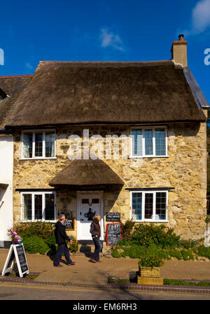 Foto von einem traditionellen strohgedeckten überdachten Teegeschäft in Fore Street Bier East Devon England UK mit ein paar Touristen außerhalb Stockfoto