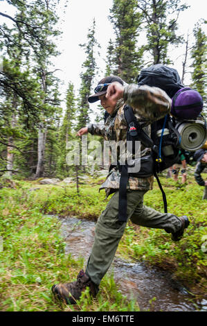 Jungen-Sprung über einen Stream während einer Rucksack-Reise durch die hohe Uintas Wilderness Area, Uintas Range, Utah Stockfoto