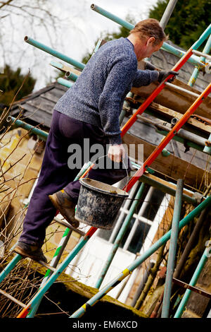 Generator auf Leiter auf einer Baustelle mit Gerüststangen und Stein Mauerwerk Stockfoto