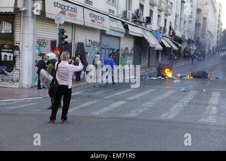 Athen, Griechenland. 16. April 2015. Ein Passant durch nimmt ein Bild von den brennenden Müll. Gewalt brach zwischen Polizei und anarchistischen Unterstützer der griechischen Hungerstreikenden in Athen. Die Auseinandersetzungen außerhalb der besetzten Pfarrhaus von der Universität von Athen begann und später nach Protest März im Bereich Exarchia. © Michael Debets/Pacific Press/Alamy Live-Nachrichten Stockfoto