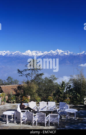 Nepal, Nagarkot, Frau im Innenhof des Hotels Fort, Fernblick über zentrale Himalaya im Hintergrund. Stockfoto