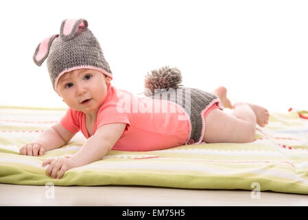 Glückliches Babymädchen Decke auflegen und gestrickte Bunny-Kostüm Stockfoto