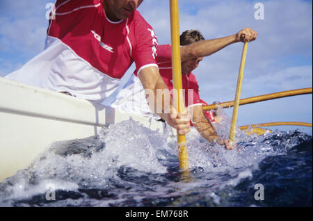 Hawaii, Oahu, close-up Winkel der Männer Outrigger Kanu paddeln, wie Klinge ins Wasser geht. Kein Model-Release Stockfoto