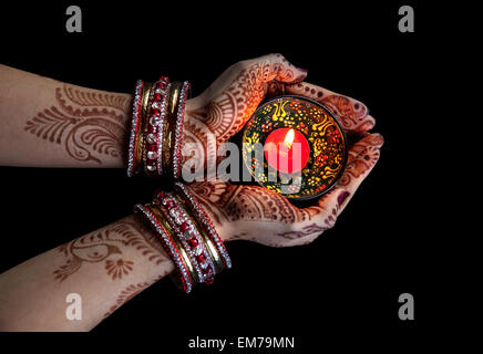 Frau Hände mit Henna mit Kerze auf Beschneidungspfad auf schwarzem Hintergrund isoliert Stockfoto
