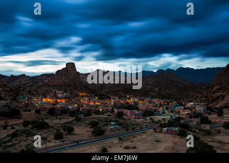 Kleinen Dorf von Aguard Oudad mit bunt bemalten Häusern vor dem Felsen Chapeau Napoleon, dramatische Wolken, Abend Stockfoto